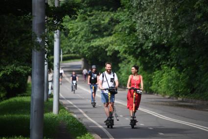 Москва. Воробьевы горы. Люди на самокатах едут по велодорожке.