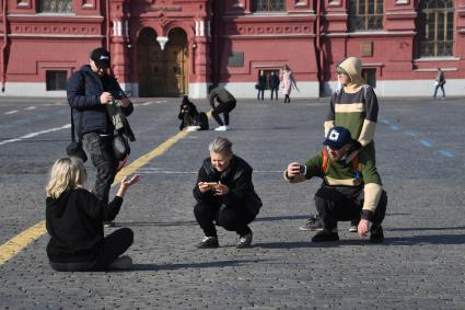 Москва.  Молодые люди фотографируются на Красной площади.