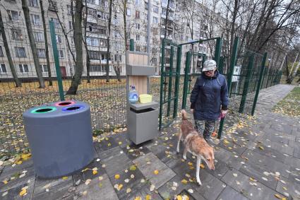 Москва. Женщина гуляет с собакой на кинологической площадке.