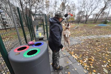 Москва. Женщина гуляет с собакой на кинологической площадке.