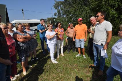 Республика Татарстан, с. Никольское. Руководитель работ Станислав Максимов и глава Никольского сельского поселения Лаишевского муниципального района Республики Татарстан Алеев Эрнест (справа налево) рассказывают местным жителям о ходе и результатах реализации проекта `Сохранение уникальных водных объектов`.