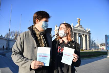 Москва. Молодые люди держат сертификат о вакцинации от коронавирусной инфекции COVID-19.
