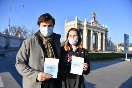 Москва. Молодые люди держат сертификат о вакцинации от коронавирусной инфекции COVID-19.