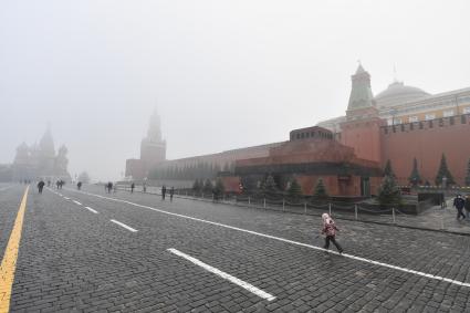 Москва. Прохожие на Красной площади  во время сильного тумана в городе.