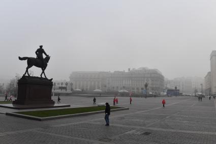 Москва. Прохожие на Манежной площади  во время сильного тумана в городе.