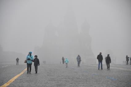 Москва. Прохожие на Красной площади  во время сильного тумана в городе.