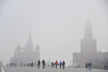 Москва. Прохожие на Красной площади  во время сильного тумана в городе.