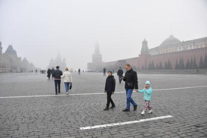 Москва. Прохожие на Красной площади  во время сильного тумана в городе.