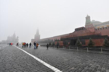 Москва. Прохожие на Красной площади  во время сильного тумана в городе.