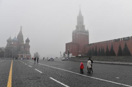 Москва. Прохожие на Красной площади  во время сильного тумана в городе.