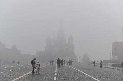 Москва. Прохожие на Красной площади  во время сильного тумана в городе.