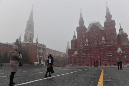 Москва. Прохожие на Красной площади  во время сильного тумана в городе.