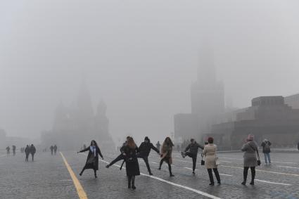 Москва. Прохожие на Красной площади  во время сильного тумана в городе.