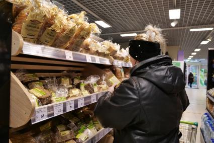 Самара. Женщина выбирает хлеб в продуктовом магазине.