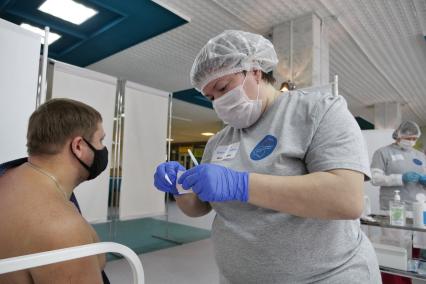 Самара. Медсестра делает мужчине прививку в пункте вакцинации от COVID-19.