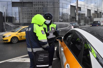 Москва.  Сотрудник ДПС на одной из улиц в Москве во время рейда по проверке соблюдения водителями такси санитарно-эпидемиологических требований.