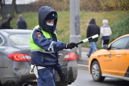 Москва.  Сотрудник ДПС на одной из улиц в Москве во время рейда по проверке соблюдения водителями такси санитарно-эпидемиологических требований.