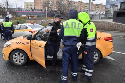 Москва.  Сотрудник ДПС на одной из улиц в Москве во время рейда по проверке соблюдения водителями такси санитарно-эпидемиологических требований.