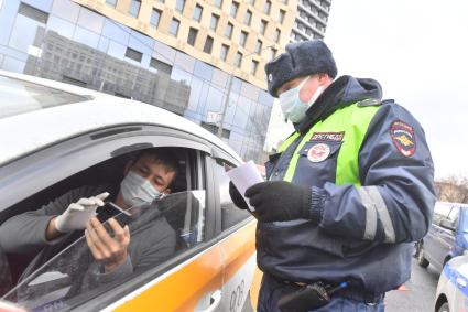 Москва.  Сотрудник ДПС на одной из улиц в Москве во время рейда по проверке соблюдения водителями такси санитарно-эпидемиологических требований.