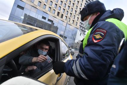 Москва.  Сотрудник ДПС на одной из улиц в Москве во время рейда по проверке соблюдения водителями такси санитарно-эпидемиологических требований.