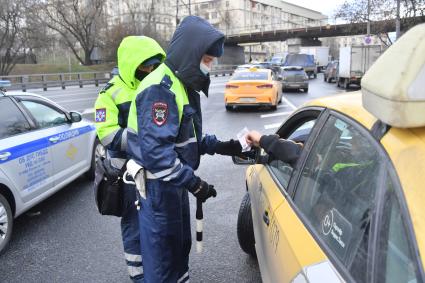 Москва.  Сотрудник ДПС на одной из улиц в Москве во время рейда по проверке соблюдения водителями такси санитарно-эпидемиологических требований.