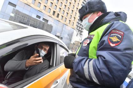 Москва. Сотрудник ДПС на одной из улиц в Москве во время рейда по проверке соблюдения водителями такси санитарно-эпидемиологических требований.