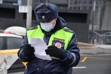 Москва.  Сотрудник ДПС на одной из улиц в Москве во время рейда по проверке соблюдения водителями такси санитарно-эпидемиологических требований.