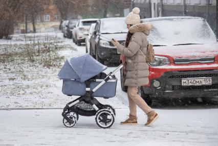 Пермь.  Женщина с коляской на заснеженной улице.