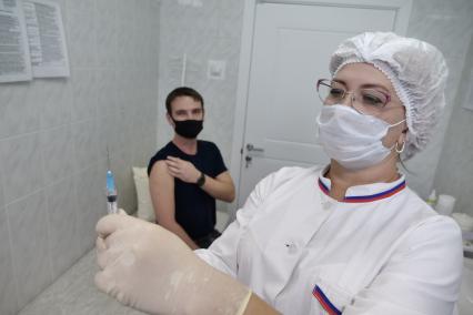 Самара. Медсестра делает мужчине прививку от коронавирусной инфекции Covid-19 в прививочном пункте больницы.