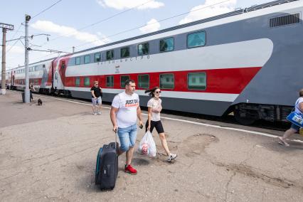 Москва.  Двухэтажный поезд с вагоном-бистро на платформе железнодорожного вокзала.