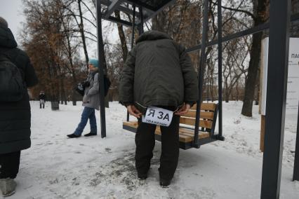 Екатеринбург. Мужчина надевает табличку с надписью \'Я за уважение к труду предков\' вов ремя митинга