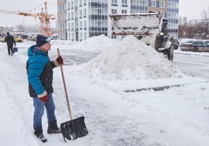 Пермь. Сотрудник коммунальных служб убирает снег.