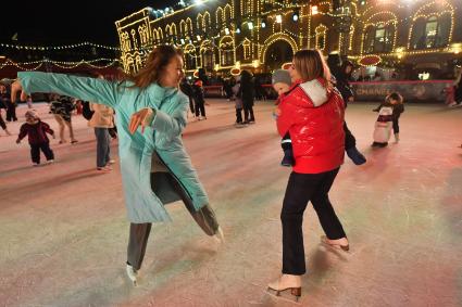 Москва. Фигуристка Екатерина Боброва (справа) с сыном на открытии ГУМ-катка на Красной площади.