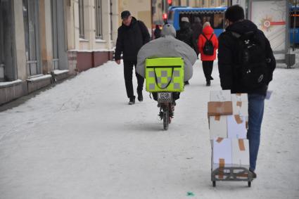 Москва. Сотрудник службы доставки на улице города.