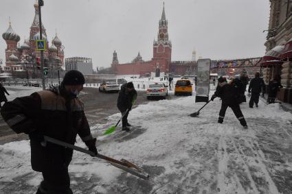 Москва.   Сотрудники коммунальных служб чистят снег на Красной площади.