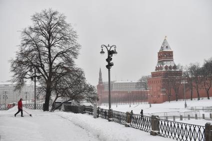 Москва.   Сотрудник коммунальных служб убирает снег на Васильевском спуске.