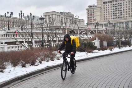 Москва. Сотрудник службы доставки на  мопеде.