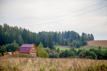 Пермский край. Село. Частные дома рядом с полем.