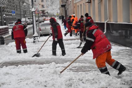 Москва. Коммунальщики убирают снег на улице.