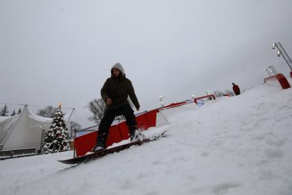 Москва. Молодой человек во время обучения основам сноубординга на ВДНХ.