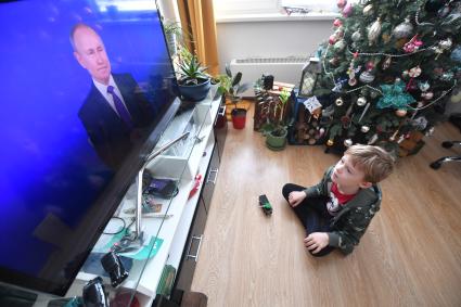 Москва. Мальчик смотрит по телевизору трансляцию ежегодной пресс-конференции президента РФ Владимира Путина.