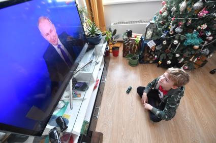 Москва. Мальчик смотрит по телевизору трансляцию ежегодной пресс-конференции президента РФ Владимира Путина.