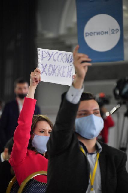 Москва. Журналистка держит листок с надписью `Русский хоккей` на  большой ежегодной пресс-конференции президента РФ Владимира Путина в ЦВЗ `Манеж`.