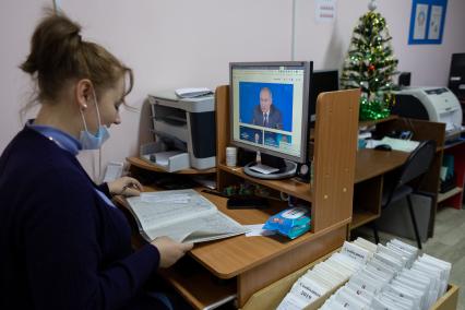 Красноярск. Женщина на рабочем месте смотрит прямую трансляцию большой ежегодной пресс-конференции президента РФ Владимира Путина на экране компьютера.