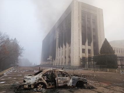 Казахстан. г.Алма-Ата. Сгоревший автомобиль возле здания мэрии (акимат). В Казахстане прошли массовые акции протестов, вызванные ростом цен на сжиженный нефтяной газ, которые потом переросли в беспорядки и погромы.