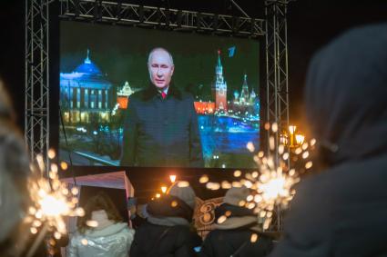 Красноярск. Люди смотрят трансляцию новогоднего обращения президента РФ Владимира Путина во время празднования Нового 2022 года.