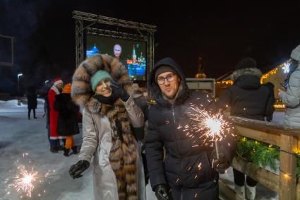 Красноярск. Молодые люди смотрят трансляцию новогоднего обращения президента РФ Владимира Путина во время празднования Нового 2022 года.