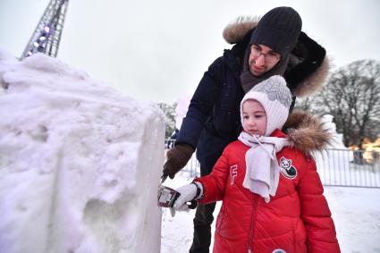 Москва.   Мужчина с девочкой на фестивале `Снег и лед в Москве`.