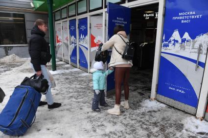 Москва. Пассажиры на Ярославском вокзале. Надпись на двери `Москва приветствует вас!`.