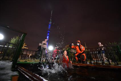 Москва. Женщина во время крещенских купаний в проруби Дворцового пруда в парке Останкино.